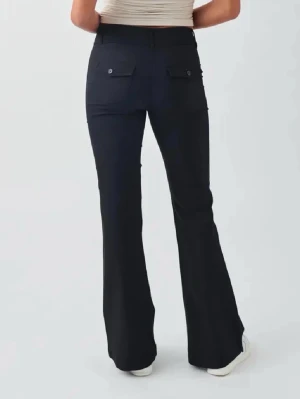 Svarta utsvängda kostymbyxor - Snygga svarta kostymbyxor med utsvängda ben och de är mid/låg midja. Byxorna har två knappar framtill och fickor med knapp bak. 