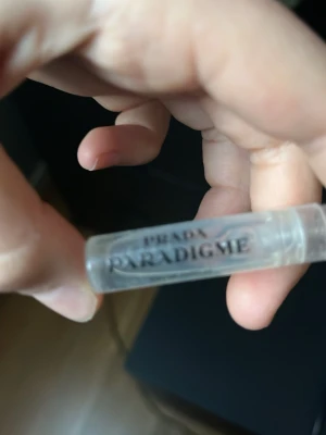 Prada Paradigme parfymprov - Litet parfymprov från Prada med doften Paradigme. Kommer i en genomskinlig plastflaska med svart text. Perfekt att ha med i väskan eller testa innan du köper en större flaska.
