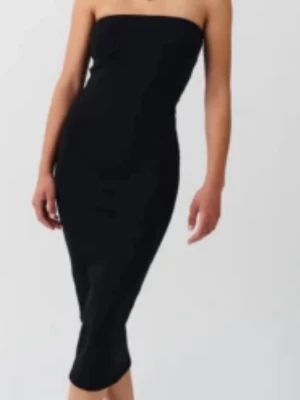 Svart axelbandslös långklänning - Stilren svart axelbandslös långklänning med figurnära passform. Klänningen har en enkel och elegant design utan synliga detaljer eller mönster, vilket gör den lätt att styla med accessoarer. Perfekt för dig som gillar minimalistisk och tidlös stil.