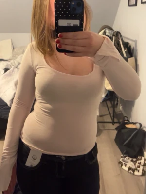 Rosa långärmad topp - Säljer en rosa, tight långärmad topp med bred, fyrkantig ringning. Toppen är enkel och stilren, perfekt att matcha med jeans eller kjol. Materialet känns mjukt och stretchigt, vilket ger en bekväm passform.