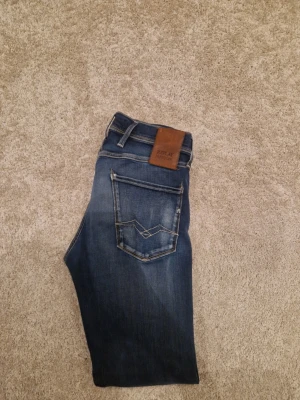Mörkblå Replay hyperflex - Snygga mörkblå jeans från Replay med klassisk femficksmodell och coola slitningar framtill. Storlek 29W 32L. Pris kan diskuteras vid snabb affär!