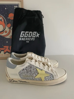 Golden Goose sneakers ⭐ - Säljer ett par Golden Goose sneakers i mycket fint skick (nyskick). Klassisk modell med glitterdetalj och gul stjärna – passar till det mesta och är både trendiga och bekväma.