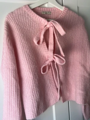Rosa stickad kofta från Gina Tricot - Supersöt rosa stickad kofta från Gina Tricot med två knytband framtill. Tröjan är helt ny och är aldrig använd💗