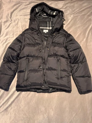 Burberry Jacka/Väst - Säljer en snygg burberry jacka. Jackan går att göra om till en väst vilket passar perfekt nu när värmen strax tittar fram. Priset är förhandlingsbart vid snabbare affärer. Fraktar oftast samma dag. Modellen på bild är 185cm lång och väger 79,2kg.