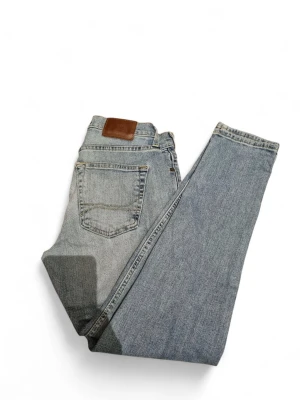 Ljusblå jeans från Hollister - Snygga ljusblå jeans från Hollister med klassisk femficksdesign och bruna sömmar. Jeansen har en rak passform och är tillverkade i slitstarkt denimtyg. Perfekta för en avslappnad och trendig look.