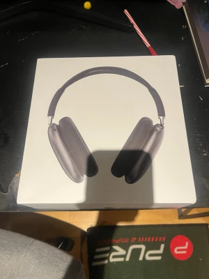 Apple AirPods Max Svart - Snygga Apple AirPods Max i svart med over-ear design och mjuka öronkuddar. Bygeln är vadderad och bågen i metall ger en exklusiv känsla. Levereras i originalförpackning med skyddsfodral. Perfekta för musik, gaming eller film.