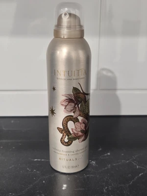 Rituals Intuita duschskum 200 ml - Lyxigt duschskum från Rituals i serien Intuita med doft av sandelträ och vanilj. Flaskan är silverfärgad med ett konstnärligt tryck av en orm och blommor. Innehåller 200 ml och har en praktisk sprayfunktion.