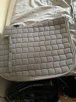 Grått schabrak med glittrig kant - Säljer ett ljusgrått schabrak från hööks med diamantkanter. Storlek full och sparsamt använt. Har inga skador eller synliga täcken på användning.