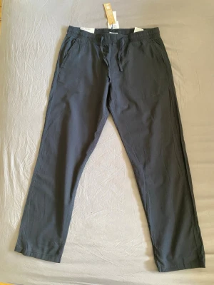 Blåa linnebyxor - Blåa linnebyxor från Jack & Jones med avslappnad passform. Storlek L. Aldrig använt (fel storlek och glömde att returnera). Nypris 499kr. 