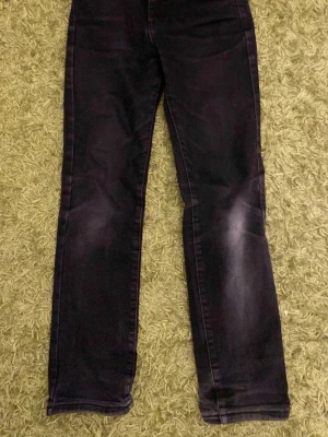 Svarta  jeans från New Yorker - Säljer ett par mörkblå jeans med raka ben och diskreta slitningar vid knäna. Jeansen har klassisk femficksdesign och är tillverkade i ett mjukt denimtyg. Perfekta för en avslappnad och stilren look.
