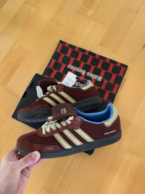 Adidas X Wales Bonnier skor 43,5 cm  - Ett par helt otroliga vinröda unika sneakers från Adidas X Wales Bonnier i storlek 43,5 cm. Nypris på närmare 10 000 kr skicket är nästintill helt nytt med tag kvar! Brutalt snygga och eftertraktade skor av högsta kvalite som är väldigt snygga och passar till allt, helt perfekta nu till sommaren och tveka inte vid minsta fråga eller fundering!