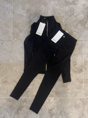 Lululemon Define Nulu set, Strl. 4/xs Tröja och byxor - Svart Färg - Super skick - Hej!   Jag säljer en väldigt snygg Lululemon Define set, storlek 4 i svart färg.  Allt är i superskick utan några slitage på märket eller andra defekter på materialet.  Tröjan och byxorna är väldigt mjuk och bekväm, vilket passar för dig som gymmar eller för sköna vardagar.  Kommer från en djur- och rökfritt hem. Fraktas alltid samma dag innan klockan 20, hör av er om ni undrar något!