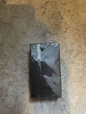Gucci Guilty Absolute Pour Homme parfym - Gucci Guilty Absolute Pour Homme är en lyxig herrparfym i en elegant mörkbrun rektangulär förpackning. Parfymen har en modern och maskulin design, perfekt för dig som gillar exklusiva dofter. Flaskan rymmer 90 ml och är tillverkad av glas med plastdetaljer.