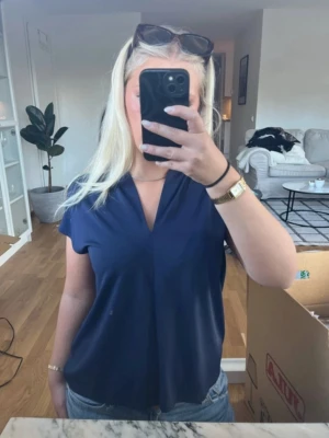 Marinblå blus i storlek M - Marinblå blus i storlek M från H&M. Skavank (se sista bilden) på baksidan av tröjan. Inget som mörks