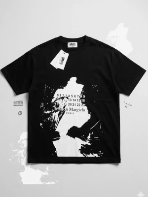 Svart Maison Margiela t-shirt - Cool svart t-shirt från Maison Margiela med vit grafisk print och logga på framsidan. Klassisk passform med rund hals och korta ärmar. Perfekt för dig som gillar streetstyle och vill sticka ut med en unik design.