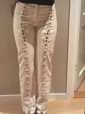 HM JEANS - Unika beiga jeans med raka ben och snygg snörningsdetalj längs hela framsidan. Hög midja och klassisk femficksmodell. Perfekta för dig som vill sticka ut med en trendig och cool look.