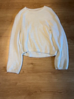 Vit fluffig stickad tröja Lindex - Mysig vit stickad tröja från Lindex i storlek 158/164. Tröjan har en fluffig och mjuk känsla, rund halsringning och långa ärmar. Bara använd några få gånger i fint skick.