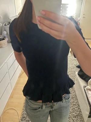Mörkblå topp med volangkant - Snygg mörkblå topp med korta ärmar och volangkant nedtill. Från Gina i strl 170 men sitter jättebra på xs/s. Skriv om ni undrar något pris kan diskuteras💕