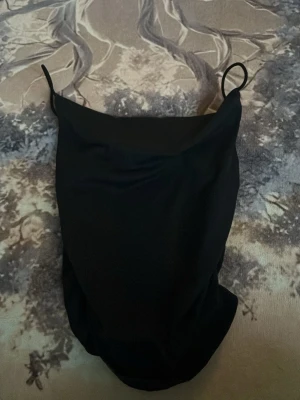 Svart linne från SHEIN - Snyggt svart linne från SHEIN i storlek XS. Klassisk modell med tunna axelband och enkel, stilren design. Materialet är stretchigt och bekvämt för en smickrande passform.