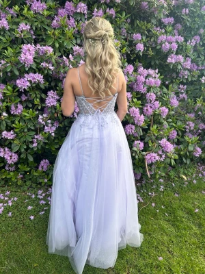 Ljuslila balklänning med snörning - Magisk ljuslila balklänning med tunna axelband och snörning i ryggen. Klänningen har ett glittrigt liv med spetsdetaljer och ett svepande, lager på lager-kjol i tyll. Perfekt för bal eller student!