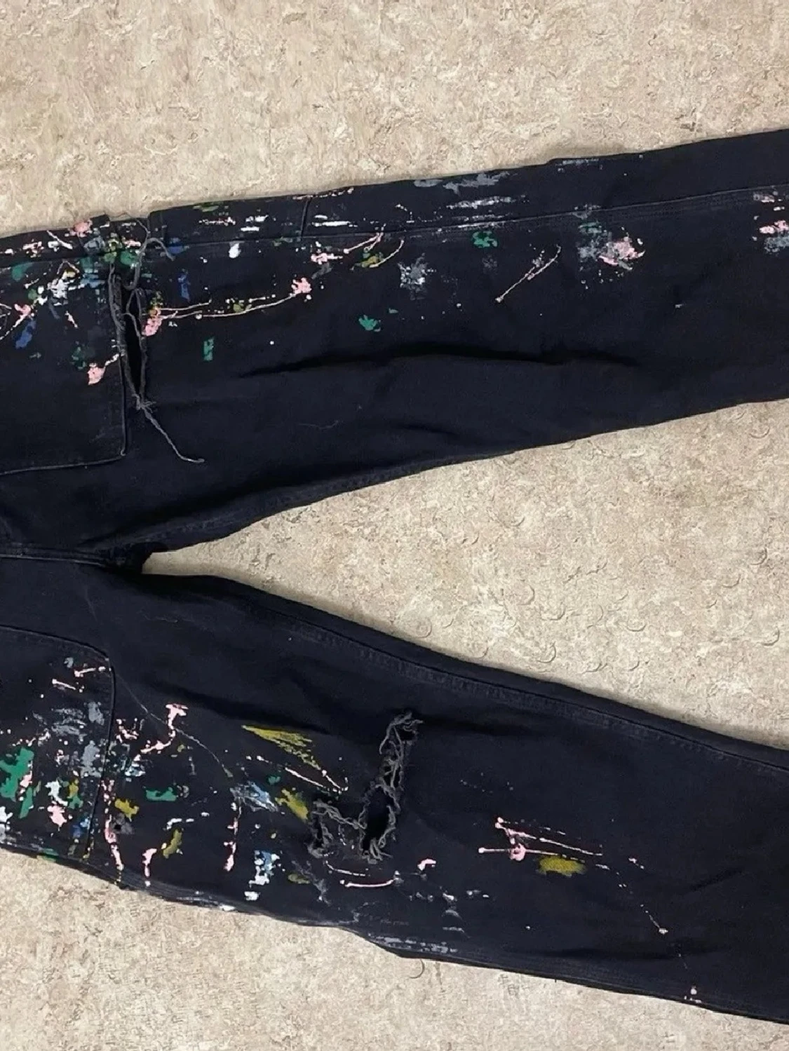 Svarta jeans med färgstänk och slitningar
