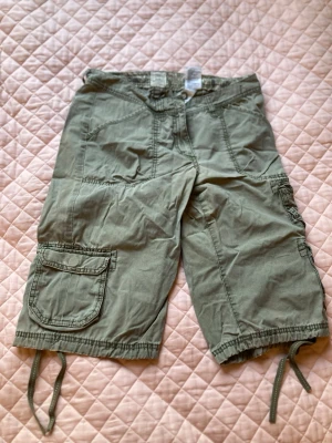 Gröna cargo shorts  - Gröna cargo shorts från HM. Lite otydligt vilket storlek dessa är men skulle säga att passformen är ungefär en 34/ en liten 36 då de är ganska små i midjan. 