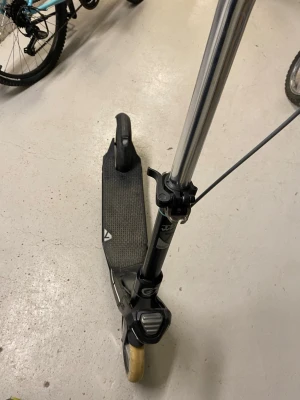 Svart sparkcykel med handbroms - Säljer en svart sparkcykel från Stiga med handbroms och stora hjul. Styret är i metall och har svarta handtag. Fotplattan har halkskydd och cykeln har en sportig design. Perfekt för att ta sig fram snabbt i stan eller på skolgården.