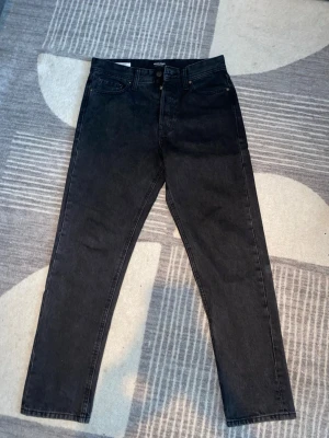 Jack&Jones Loose/Chris 29/32 - Snygga svarta jeans från Jack&Jones med rak passform och klassisk femficksdesign. Jeansen har hög midja och är tillverkade i ett mjukt denimtyg som ger en skön känsla. Perfekta för en trendig och avslappnad stil.