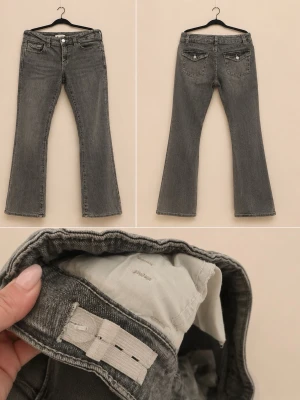 Grå bootcut jeans från Gina tricot - Snygga grå bootcut jeans från Gina med klassisk femficksdesign och silverfärgade detaljer. Jeansen har en lätt utsvängd passform och är tillverkade i ett mjukt denimtyg. Perfekta för en avslappnad men trendig look.