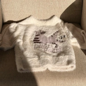 Vit fluffig stickad tröja - Supersöt vit stickad tröja i fluffigt material. Tröjan har rund hals och korta ärmar, köpte på taobao, butiken där heter 1Jinn Studio, har mera bilder där jag har på mig den kan skicka privat