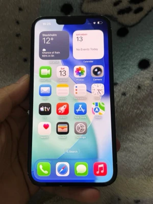 iPhone 14, 128 GB, Svart - Snygg svart iPhone 13 med stilren design och två stora kameror på baksidan. Telefonen har en platt framsida med tunn ram och en tydlig skärm. Baksidan är i glas och sidorna är mattsvarta. Perfekt för dig som gillar Apple och vill ha en modern smartphone.