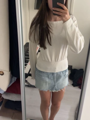 Vit långärmad topp från Gina Tricot - Säljer en stilren vit långärmad topp från Gina Tricot. Toppen har bred ribbad mudd i midjan och vid ärmsluten, vilket ger en snygg passform. Tillverkad i mjukt bomullsmaterial och har en enkel, clean look som passar till allt. Prislapp kvar!