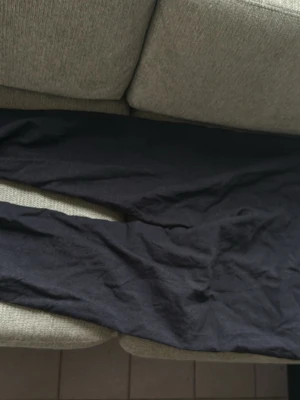 Mörkblå raka jeans - Säljer ett par mörkblå jeans med rak passform och klassisk femficksdesign. Jeansen har knappgylf och bälteshällor i midjan. Materialet ser ut att vara denim, perfekt för en avslappnad stil. Coola byxor väldigt unika!