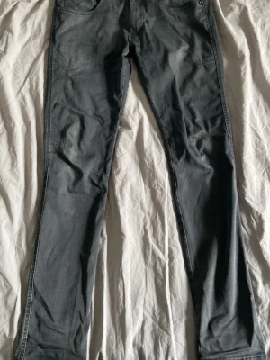 Replay ripped jeans anbass  - Säljer ett par grå jeans med raka ben och klassisk femficksmodell. Jeansen har diskreta sömmar och en snygg detalj på bakfickan. Perfekta till en avslappnad stil och passar till det mesta. Materialet känns mjukt och följsamt.