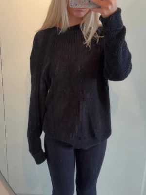 Svart stickad tröja med rund hals - Mysig svart stickad tröja med rund halsringning och långa ärmar. Tröjan har en grovstickad struktur och ribbade muddar vid ärmslut och nederkant. Perfekt för lager på lager och enkel att matcha till olika outfits. Är köpt på mansavdelning i storlek S men jag som är xs har använt den.