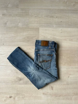 Blåa Nudie Jeans Grim Tim Storlek W30 L32 - Mycket fina Nudie jeans i blå färg | Jeansen är i mycket bra skick och sparsamt använda. |  Äkta som allt annat jag säljer! ✅ |  Storlek: W30 L32 | Skick: Mycket Bra Skick - tyvärr några små slitningar och lagningar (SE SISTA BILDER)| Färg: Blå | Märke: Nudie | Modell: Jeans |   Hör gärna av dig vid frågor så svarar jag så fort jag kan! 😁 |  (SKU - 171)