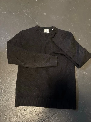 Tröja Bläck - Snygg svart/mörkblå stickad tröja från Bläck med diskret strukturmönster. Tröjan är i fint skick och fri från fläckar. Tröjan är lite knottrig men inget illa. Bör gå att få väck med knottermaskin. Bara att höra av dig vid funderingar💪🏼😄