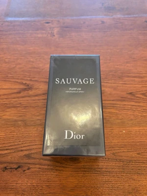 Dior Sauvage Parfum - Dior Sauvage Parfum är en exklusiv herrparfym i en elegant svart rektangulär förpackning. Doften är intensiv och modern, och flaskan har en stilren design med tydlig Dior-logga. Perfekt för dig som vill ha en lyxig och tidlös signaturdoft.