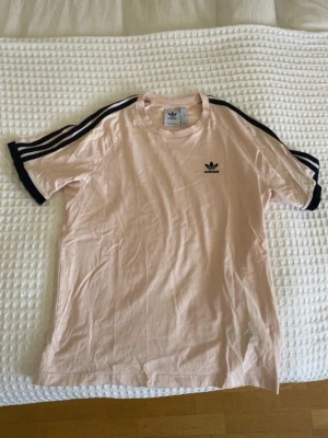 Adidas originals t-shirt - Adidas originals t-shirt i storlek S. I en vit/ljusrosa färg med marinblåa ränder. Jättebra skick.