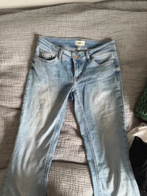 Ljusblå jeans från ONLY - Säljer ett par ljusblå jeans från ONLY med klassisk femficksmodell och låg midja. Jeansen har en snygg tvättad look och raka ben. Perfekta för en avslappnad och trendig stil. Storlek xs längd 32