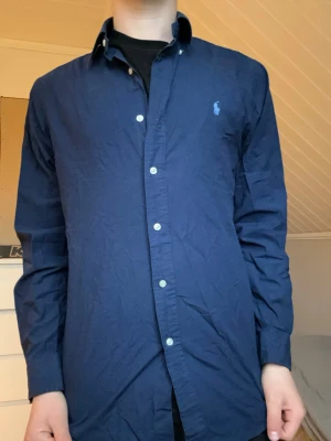 Mörkblå skjorta från Ralph Lauren - Säljer denna Ralph Lauren skjortan i storlek M.  Modellen är 175 och väger 65kg.  Skriv vid frågor
