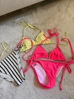 Tre bikinis - Säljer tre bikinis, en gul överdel från shein i storlek xxs. En randig bikini underdel från hm i storlek 36. Och en neon rosa bikini från shein i storlek xxs. Bra skick