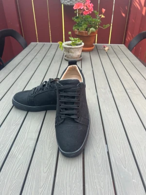 Svarta Louboutin skor  - Riktigt schyssta skor från Christian Louboutin i mocka. Skorna funkar för alla tillfällen. Om du ska till skolan, till jobbet eller även om du har kostym på dig så kommer den att se bra ut. Skorna har en riktig schysst och unik röd sula som kommer få dig att stikia ut. Priset kan förhandlas.