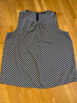 Linne more by stockh lm - Säljer en luftig ärmlös blus med svartvitt geometriskt mönster. Toppen har rund halsringning och dragkedja bak. Perfekt till jeans eller kjol för en snygg och enkel look.