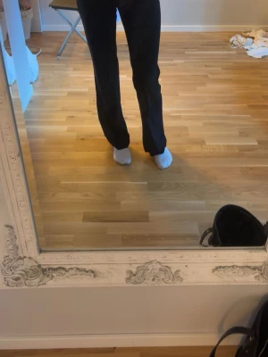Svarta vida kostymbyxor - Stilrena svarta kostymbyxor med mellan midja och raka, något vida ben. Klassisk passform som ger en clean och modern look. Byxorna har få synliga detaljer framtill och är perfekta för dig som gillar få detaljer. Dom kommer ej till användning tvättas innan jag skickar dom.