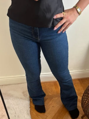 Mörkblå bootcut jeans - Säljer ett par mörkblå bootcut jeans som formar kroppen väldigt fint. De är köpta ifrån Zara och är slutsålda på sidan. Aldrig använda. Säljes pga de är för små för mig. Jeansen är uppsydda vid benen men det går enkelt att sprätta upp.