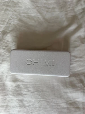 Svarta solglasögon från CHIMI - Snygga svarta solglasögon från CHIMI med fyrkantig form och mörka glas. Kommer i originalfodral med CHIMI-logga. Perfekta för att lyfta din stil och skydda ögonen mot solen.