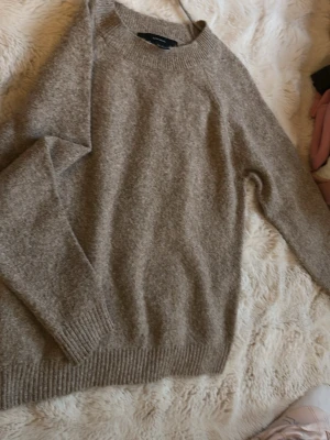 Beige stickad tröja från Vero Moda - Mysig beige stickad tröja från Vero Moda med rund halsringning och ribbade muddar vid ärmslut och nederkant. Perfekt för lager-på-lager och enkel att matcha med jeans eller kjol. Materialet känns mjukt och skönt mot huden.