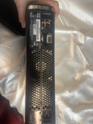 Xbox 360 Slim svart spelkonsol - Säljer en svart Xbox 360 Slim från Microsoft. Konsolen har en stilren, matt finish och rundade kanter. På baksidan finns flera portar för HDMI, USB och nätverk. Perfekt för gaming och retrospel!