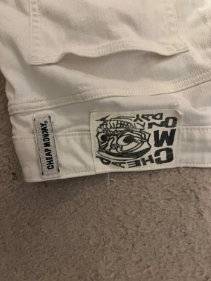 Nya! jeans från Cheap Monday - Säljer ett par vita jeans från Cheap Monday med klassisk logga bak på linningen. Jeansen har raka ben och är tillverkade i ett kraftigt bomullstyg. Perfekta för dig som vill ha en clean och stilren look.